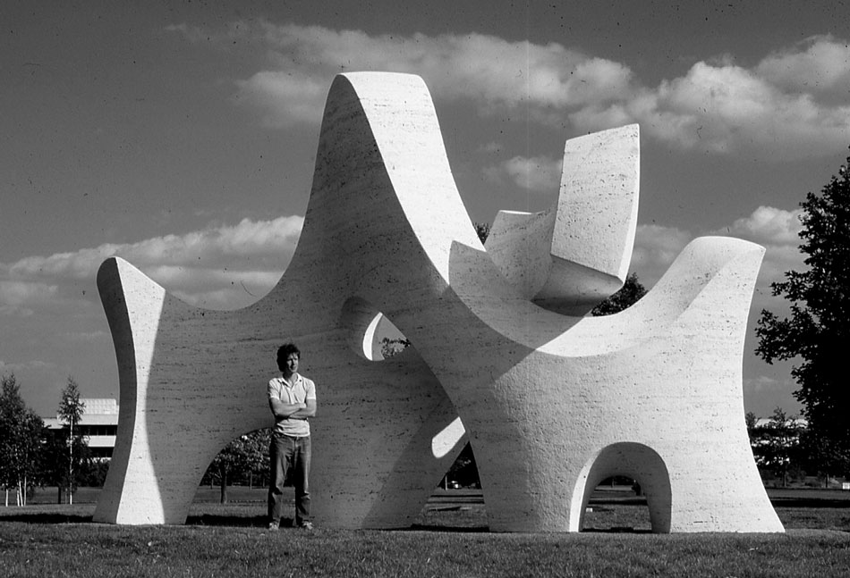 PASSAGE seen from the other side, revealing the seperated element interacting with the swept curve. The artist is posed with the work. richard-erdman-passage